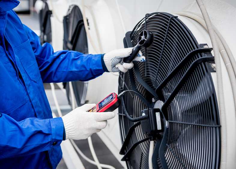 Worker checking large cooling fan