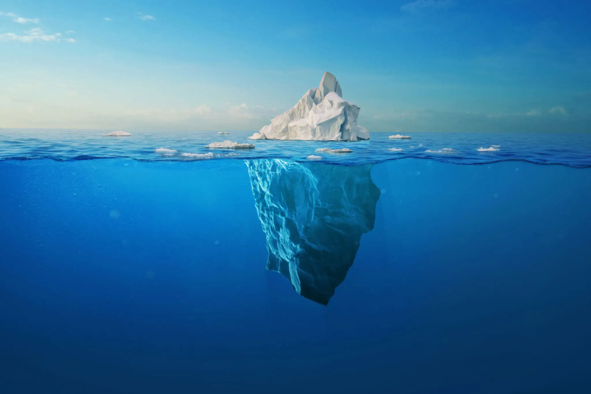 Iceberg with underwater portion visible in ocean.