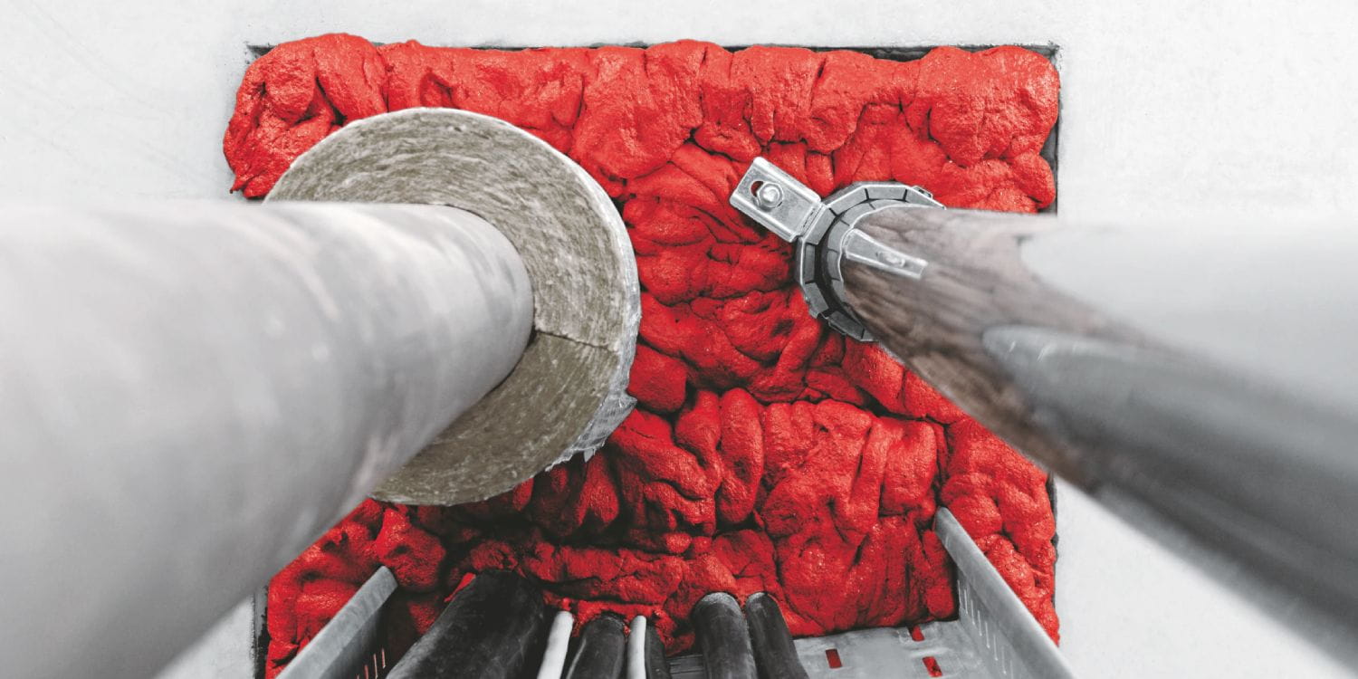 Red insulation around pipes in a ceiling.
